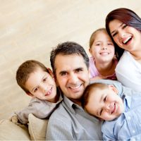 child custody Family smiling together on a couch, representing family unity and child custody themes in family law.