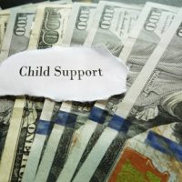 Child support payment represented by cash bills with a label reading "Child Support," relevant to Illinois child support and wage garnishment laws.