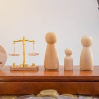 substance abuse and child custody Wooden figurines representing a family beside a golden scale, symbolizing child custody and legal decisions in family law.