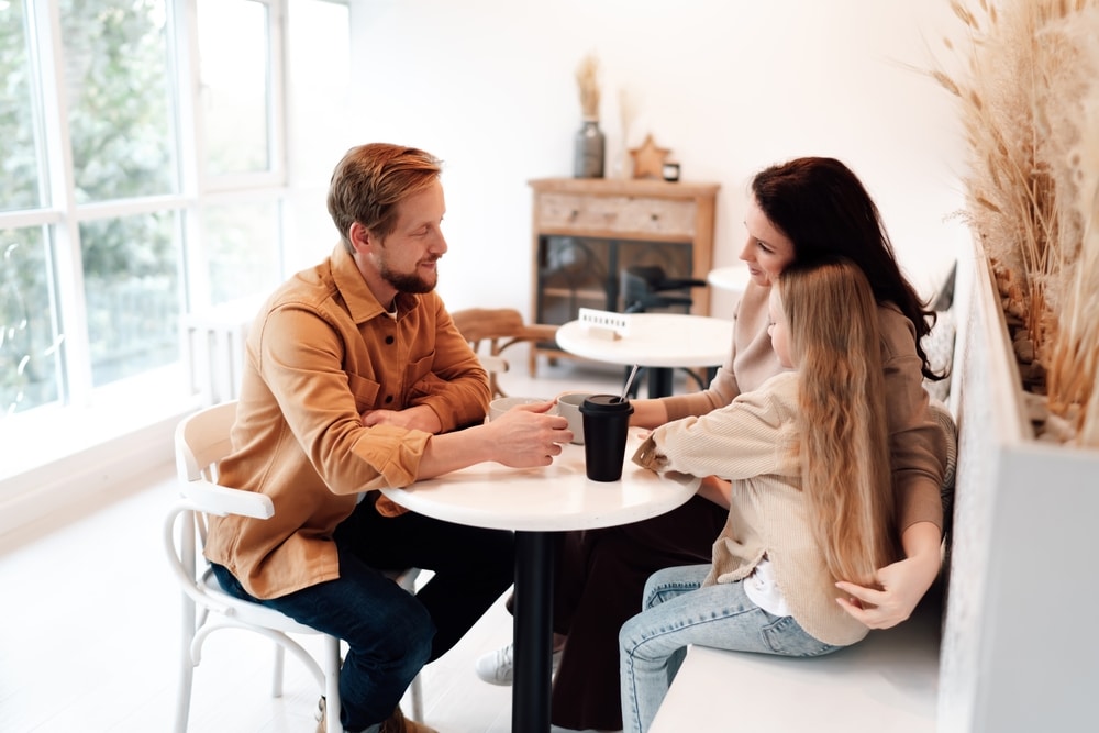 FamilyTrioSharesCoffeeAtCozyCafeEmphasizingEyeContact FamilyTrioSharesCoffeeAtCozyCafeEmphasizingEyeContact