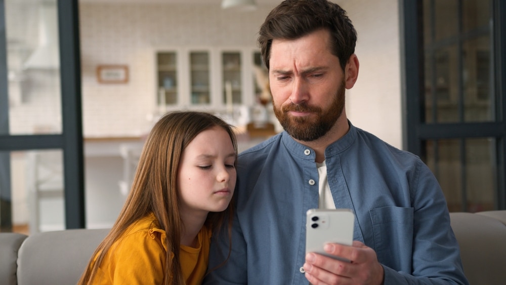 DisappointedCaucasianFamilyGuyManParentFatherHoldingMobilePhone