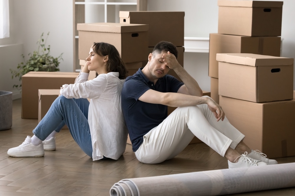 TiredFrustratedMarriedCoupleSittingBack-to-backOnFloorSurroundedBy TiredFrustratedMarriedCoupleSittingBack-to-backOnFloorSurroundedBy