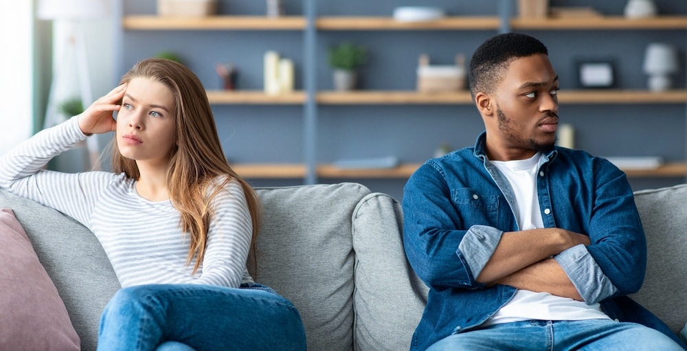 RelationshipCrisisOffendedInterracialCoupleSittingOnCouchAfterQuarrel