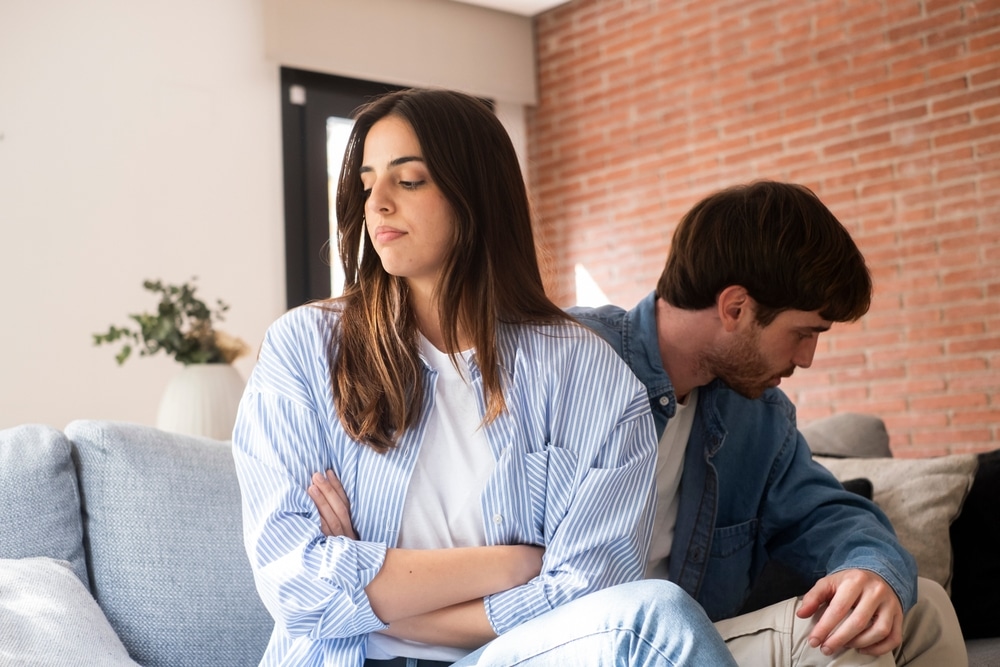SadCoupleInATenseDiscussionAtHomeSeatedOn SadCoupleInATenseDiscussionAtHomeSeatedOn