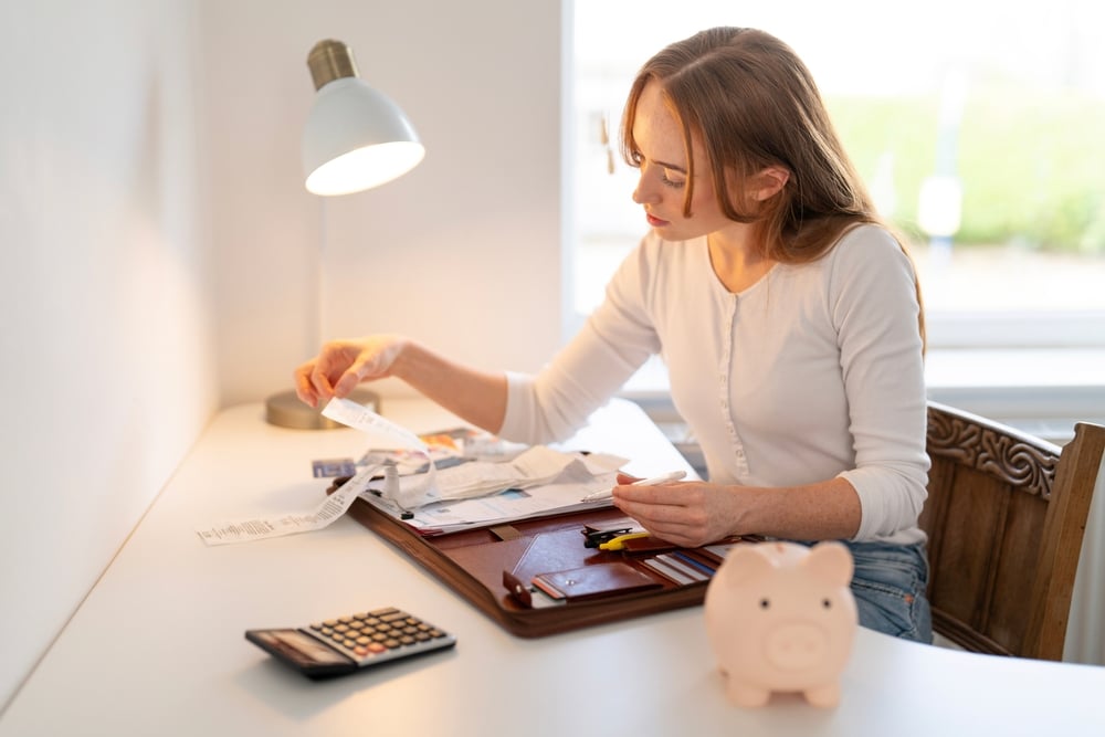 WomanOrganizingReceiptsAndManagingFinancesAtADeskIn